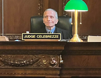 Judge Celebrezze sitting on the judge's bench with a green lamp on the bench