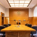 View facing bench in remodeled Court of Appeals Courtroom 3 featuring large hardwood attorney table with accessible outlets and conferencing technology and wood panel bench to accommodate three-judge panels.